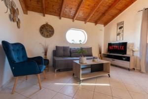 a living room with a couch and a tv at Oula Maisonettes Suites in Kavos