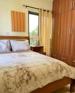 Un dormitorio con una cama grande y una ventana en Green Court Serviced Apartments, en Accra