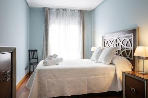 - une chambre avec un grand lit blanc et une fenêtre dans l'établissement Como en casa, à Oviedo