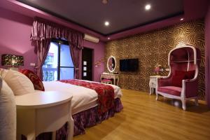 1 dormitorio con 1 cama, mesa y sillas en Holland Windmill B&B, en Hualien City