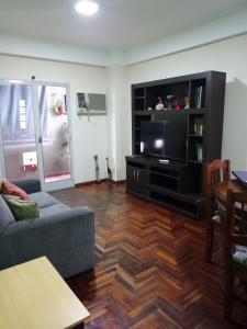 a living room with a couch and a flat screen tv at Rincón Verde in San Miguel de Tucumán