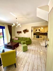 a living room with a green couch and a table at Fourka House in Kassandra