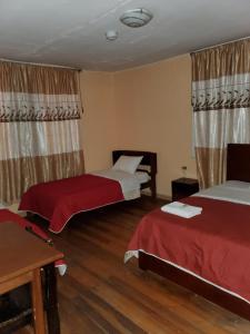 a hotel room with two beds and a table at Hostal Bolívar Inn in Quito