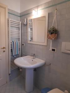 W łazience znajduje się biała umywalka i lustro. w obiekcie Porta Marina w mieście Recanati