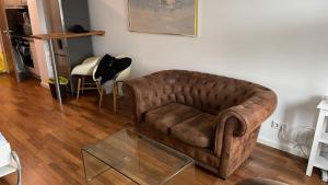 sala de estar con sofá marrón y mesa de cristal en Apartment in München en Múnich