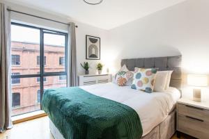 a bedroom with a bed and a large window at Best City Centre Luxurious Home Free Parking in Belfast