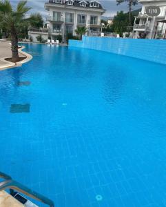 a large blue swimming pool in front of a building at Orka world in Fethiye