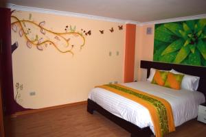 ein Schlafzimmer mit einem Bett und einem Wandgemälde in der Unterkunft La Kapital Hotel in Ambato
