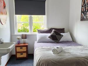 sypialnia z łóżkiem, umywalką i oknem w obiekcie The Garston Lodge w mieście Garston