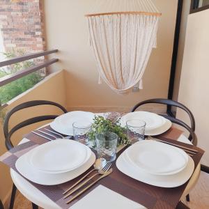 a dining room table with white plates and silverware at Syrena Luxury Caribbean in Playa del Carmen