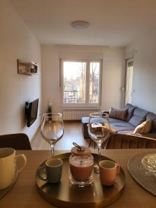una sala de estar con una mesa con copas de vino. en Zemunske kapije, en Novi Grad