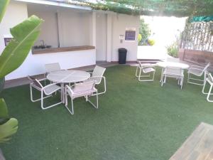 una habitación con mesas y sillas en una alfombra verde en Hotel Maioris Bellavista, en Culiacán