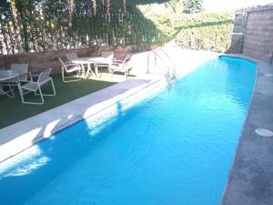 a swimming pool with a table and chairs next to it at Hotel Maioris Bellavista in Culiacán
