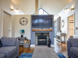 a living room with a fireplace with a tv above it at Cranesbill in Bamburgh