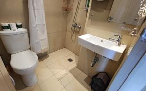 a bathroom with a toilet and a sink at Studio18 Elpis Kemayoran JIEXPO Sunrise View -Min Stay 3 nights- in Jakarta
