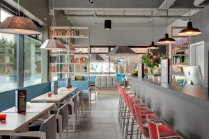 a row of tables and chairs in a restaurant at MEININGER Hotel Berlin Airport in Berlin