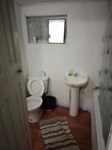 a bathroom with a toilet and a sink at Cabañas Josabi in Concepción