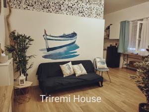 a living room with a couch and a painting of a boat at Triremi house in Lido di Ostia