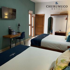a hotel room with two beds and a desk at HOTEL CHURUMUCO in San José Iturbide