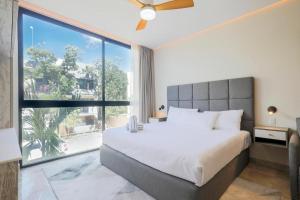 a bedroom with a large bed and a large window at Apartamento Aldea Zama 7 in Tulum +10 photos
