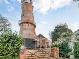 an old brick lighthouse in front of a house at Sutton Windmill in Hickling