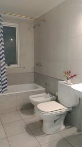 a bathroom with a toilet and a tub and a sink at Departamento el estadio in Santiago del Estero