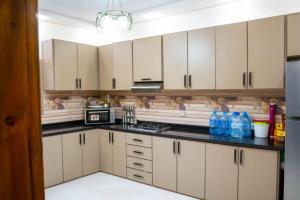 a kitchen with white cabinets and black counter tops at Riad dar asalam in Agadir