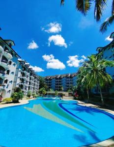 a large swimming pool in front of some buildings at Seri Lagenda Apartment in Kuah