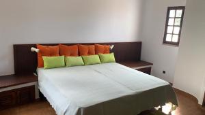 a bedroom with a bed with orange and green pillows at Vila sol in Armação de Pêra