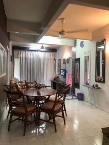 a dining room with a wooden table and chairs at Seri Lagenda Apartment in Kuah