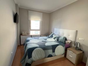 a bedroom with a bed with a blue and white comforter at Las Catedrales Altar Beach in Barreiros