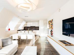Il comprend un salon doté d'un mobilier blanc et une salle à manger. dans l'établissement Modern apartment in Koksijde with balcony, à Coxyde
