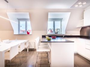 - une cuisine avec des placards blancs, une table et des chaises dans l'établissement Modern apartment in Koksijde with balcony, à Coxyde