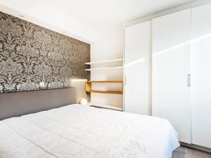- une chambre avec un lit blanc et un mur dans l'établissement Modern apartment in Koksijde with balcony, à Coxyde