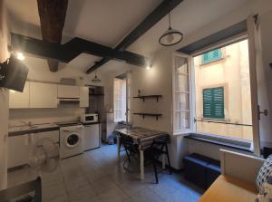 a kitchen with a table and a sink and a washing machine at A casa di Silvia in Camogli