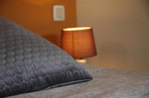 een kussen bovenop een bed met een lamp bij Twinkeling Lights in Kluisbergen