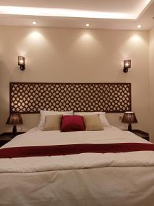 ein Schlafzimmer mit einem großen Bett mit zwei Lampen in der Unterkunft Relax Guest House in Madinat as-Sadis min Uktubar