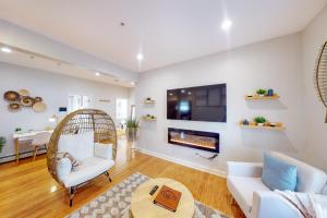 uma sala de estar com uma cadeira de vime e uma lareira em Five75 Lux BOS - Boho Chic em Boston