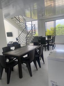 a dining room with tables and chairs and a staircase at Villa Nila in Carmen de Apicalá