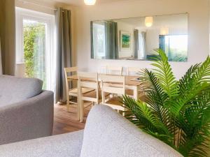 a living room with a couch and a dining room at Courtfield Bungalow in Totnes