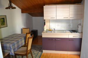 a kitchen with a sink and a table with chairs at Apartment Selce 2372c in Selce