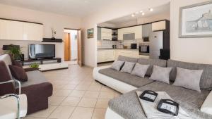 a living room with a couch and a kitchen at Family friendly house with a swimming pool Katuni, Zagora - 20651 in Šestanovac