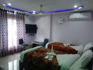 En eller flere senger på et rom på Kaziranga Guest House, kohora Home