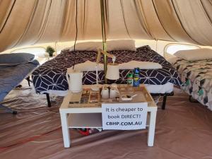 a tent with a bed and a table with a sign at Coonawarra Bush Holiday Park in Coonawarra