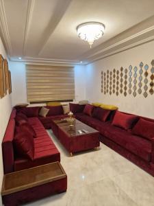 ナドールにあるNice appartment nador al jadidのリビングルーム(赤いソファ、コーヒーテーブル付)
