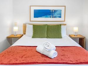 a bedroom with a bed with a towel on it at Blue on Blue Superior Studio Room 1351 in Nelly Bay