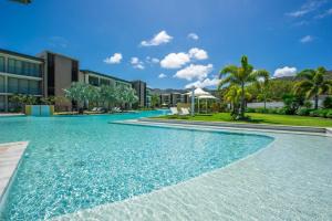 una piscina de agua azul frente a los edificios en Blue on Blue Superior Studio Room 1351 en Nelly Bay