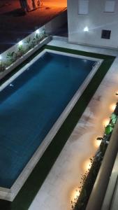 a swimming pool with lights in a house at Sublime appartement le Palace Hammamet Nord Mrezga in Hammamet