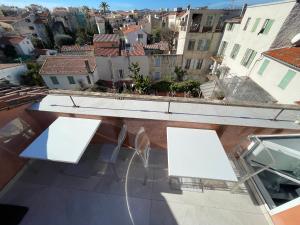 two white tables and chairs on a balcony with buildings at Rue Guillaumont heart of old Antibes in Antibes