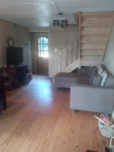 a living room with a couch and a staircase at Peumayen in Quellón